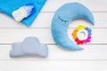Baby sleep pattern with moon pillow, cloud, feeding bottle and toy on white wooden background top view