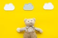 Baby care. Newborn baby concept. Baby sleep concept. Teddy bear toy near clouds on yellow background top view copy space