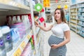 Baby care powder pregnancy woman shopping. Young pregnant woman buying on baby bath shampoo bottle on supermarket Royalty Free Stock Photo