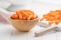 Baby carrot vegetable in bowl. Mini orange carrots on white table