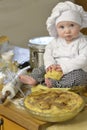 Baby chef  portrait of toddler with baking ingredients making a pie Royalty Free Stock Photo