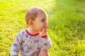 Baby with chicken pox rash sitting at green grass