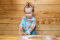 Baby child boy cooking, playing with flour at wooden kitchen.