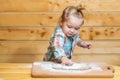 Baby child boy in the kitchen helping with cooking, playing with flour. Little boy child laying on very messy kitchen