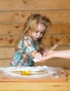 Baby child cooking, playing with flour at wooden kitchen.