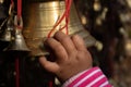 A BABY CHILD GIRL HAND TOUCHES A BIG BRASS BELL
