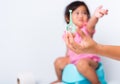 Baby child girl training to sitting on blue chamber pot or potty her problem cannot shit and mother use Enema Royalty Free Stock Photo