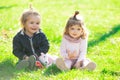 Baby child on the green grass in summer park. Brother and sister play together in a green meadow. Happy children playing Royalty Free Stock Photo