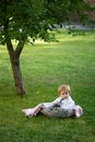 Baby child on the green grass in summer park. Children playing in the green grass on summer field. Children on pirnic.