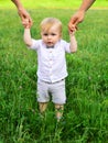 Baby child on the green grass in summer park. Parents hand and child. Perfect family holding hands, adopted child being Royalty Free Stock Photo