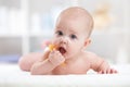 Baby child lying on belly weared with teether in mouth Royalty Free Stock Photo