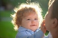 Baby child and mother on sunny day. Kids face, little boy portrait. Childhood and parenting concept. Royalty Free Stock Photo