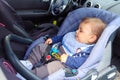 Baby child sleeping in car seat with safety belt locked protection Royalty Free Stock Photo