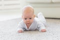 Baby, childhood, people concept - Portrait of a crawling baby on the floor