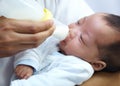 Baby with cleft lip, milk and mom feeding from bottle for nutrition, health and wellness. Formula, newborn and hand of Royalty Free Stock Photo