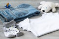 Baby clothes and accessories with white bear toy on a wooden background Royalty Free Stock Photo