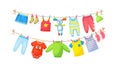 Baby clothes hanging on clothesline. Drying children`s clothes and accessories after washing on rope. Shorts, socks, romper, Royalty Free Stock Photo