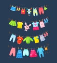 Baby clothes hanging on clothesline. Drying children`s clothes and accessories after washing on rope. Shorts, socks, romper, Royalty Free Stock Photo