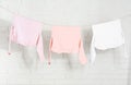 Baby clothes hanging on washing line near brick wall Royalty Free Stock Photo