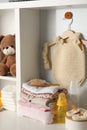 Baby clothes, toy and accessories on white rack Royalty Free Stock Photo