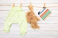 Baby clothes and  toy bunny on a clothesline on wooden background  - Image Royalty Free Stock Photo