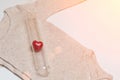 Baby clothes with vial and heart. Concept - IVF, in vitro fertilization. Waiting for baby, pregnant. Toned Royalty Free Stock Photo