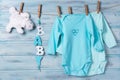Baby clothes, white toy bear and word baby on a clothesline Royalty Free Stock Photo