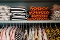 baby clothing sets with animal prints arranged on a shelf