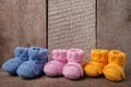 Baby concept: different colored baby booties, Three pairs of baby booties on a wooden background.