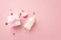 Baby concept. Top view photo of white gift box with bow pacifier milk bottle and shiny confetti on isolated pastel pink background Royalty Free Stock Photo