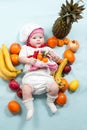 Baby cook girl wearing chef hat with fresh fruits. Royalty Free Stock Photo