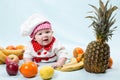 Baby cook girl wearing chef hat with fresh fruits. Royalty Free Stock Photo