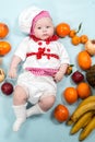 Baby cook girl wearing chef hat with fresh fruits. Royalty Free Stock Photo