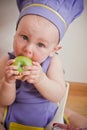 Baby cooking at the kitchen eating apple Royalty Free Stock Photo