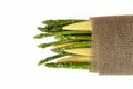 Baby corn and asparagus in a sackcloth isolated on white Royalty Free Stock Photo