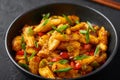 Baby Corn Manchurian dry looks like Schezwan Baby Corn in black bowl at dark slate background