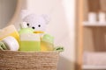 Baby cosmetic products, bath accessories and toy bear in wicker basket indoors, closeup. Space for text Royalty Free Stock Photo