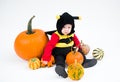 Baby in costume with pumpkins on white background