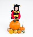 Baby in costume with pumpkins on white background