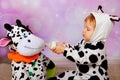 Baby in cow costume feeding a cow mascot