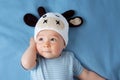 Baby in a cow hat on blue blanket