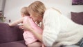 Baby crawling away mother. Cheerful kid walking on sofa Royalty Free Stock Photo