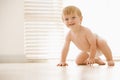 Baby crawling indoors smiling