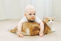 Baby crawls plays with cat home on floor