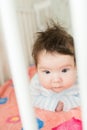 Baby in the crib. Funny baby in a white canopy bed. Children`s room interior and bedding for children. Laughing little boy playin Royalty Free Stock Photo