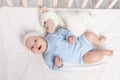 Baby in the crib, laughing baby 3 months lying with a teddy bear toy, children and birth concept Royalty Free Stock Photo