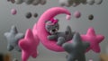 Baby crib mobile ornaments hangings close up, grey wool felt bear sleeps on a pink plushie moon, surrounded by stars