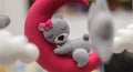 Baby crib mobile ornaments hangings close up shot, grey wool felt bear sleeps on a red plushie moon, surrounded by soft clouds