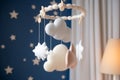 Baby crib mobile with stars, clouds and moon. Kids handmade toys above the newborn crib. First baby eco-friendly toys made from