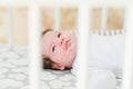 Baby in the crib. Newborn baby boy in bed. New born child sleeping under a white knitted blanket. Children sleep. Bedding for kids Royalty Free Stock Photo